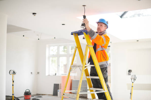 Local electrician installing ceiling fixtures during a home upgrade