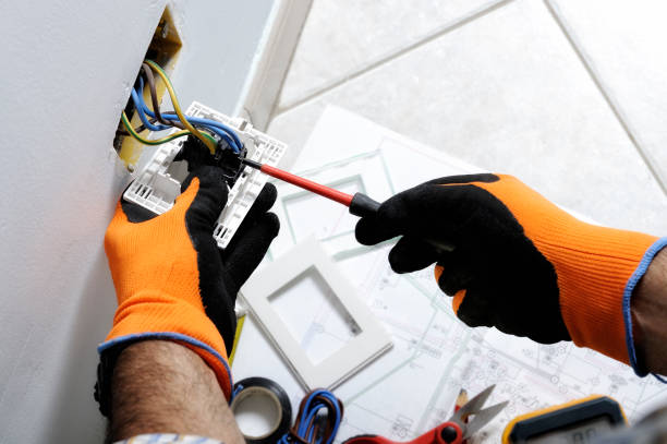 Electrician installing a new wall socket with precision and care